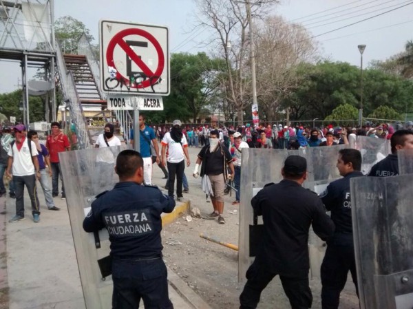 Chocan policías y normalistas que exigen plaza automática; los gases alcanzaron una escuela primaria