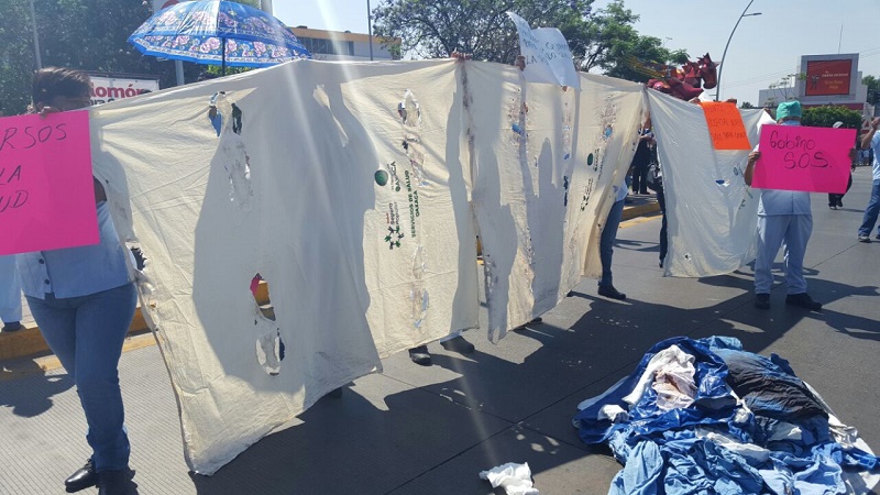 Cuelgan ropa hospitalaria en Fuente de las Ocho Regiones para denunciar foco de infección