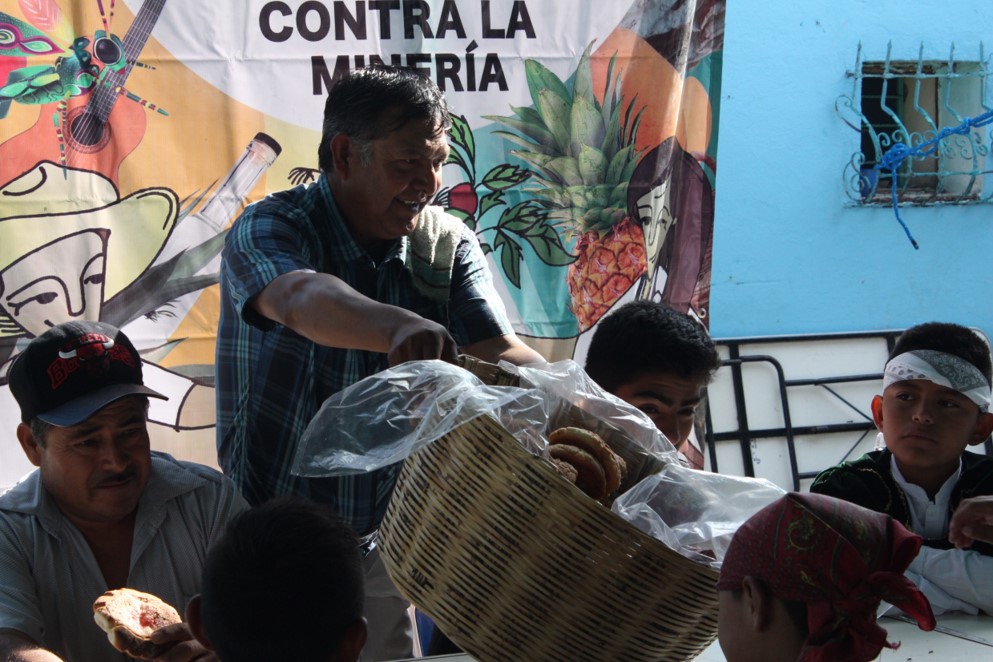 señor repartiendo pan en el compartir de la verdadera Guelaguetza contra la minería pagina 3