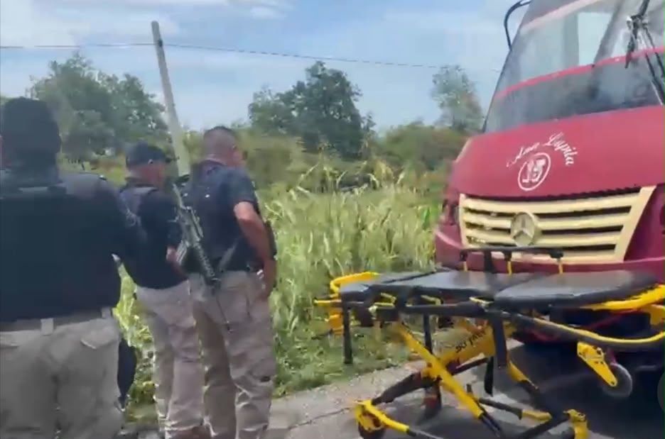Elementos de seguridad y una camilla de emergencia frente al autobús atacado en Juchitán