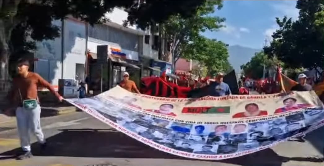 Integrantes del MULT marchan en Oaxaca con manta por justicia para víctimas triquis