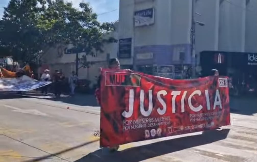 Manta roja del MULT con la palabra justicia durante marcha en Oaxaca