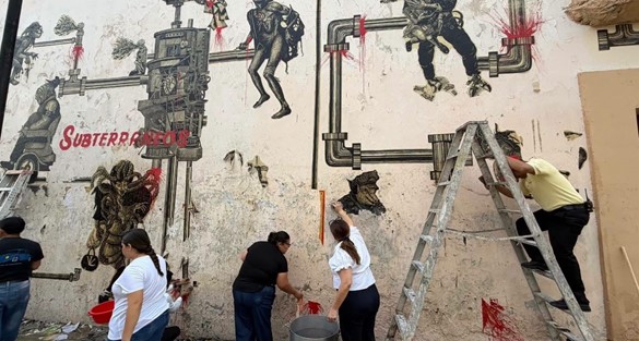 Integrantes del colectivo pintando paredes