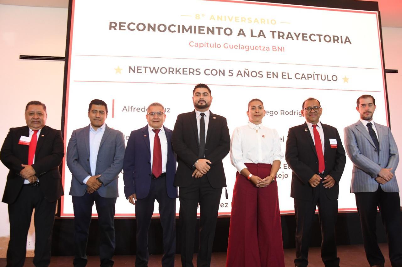 Siete integrantes del capítulo posan frente a una pantalla que dice Reconocimiento a la trayectoria, networkers con cinco años en el capítulo