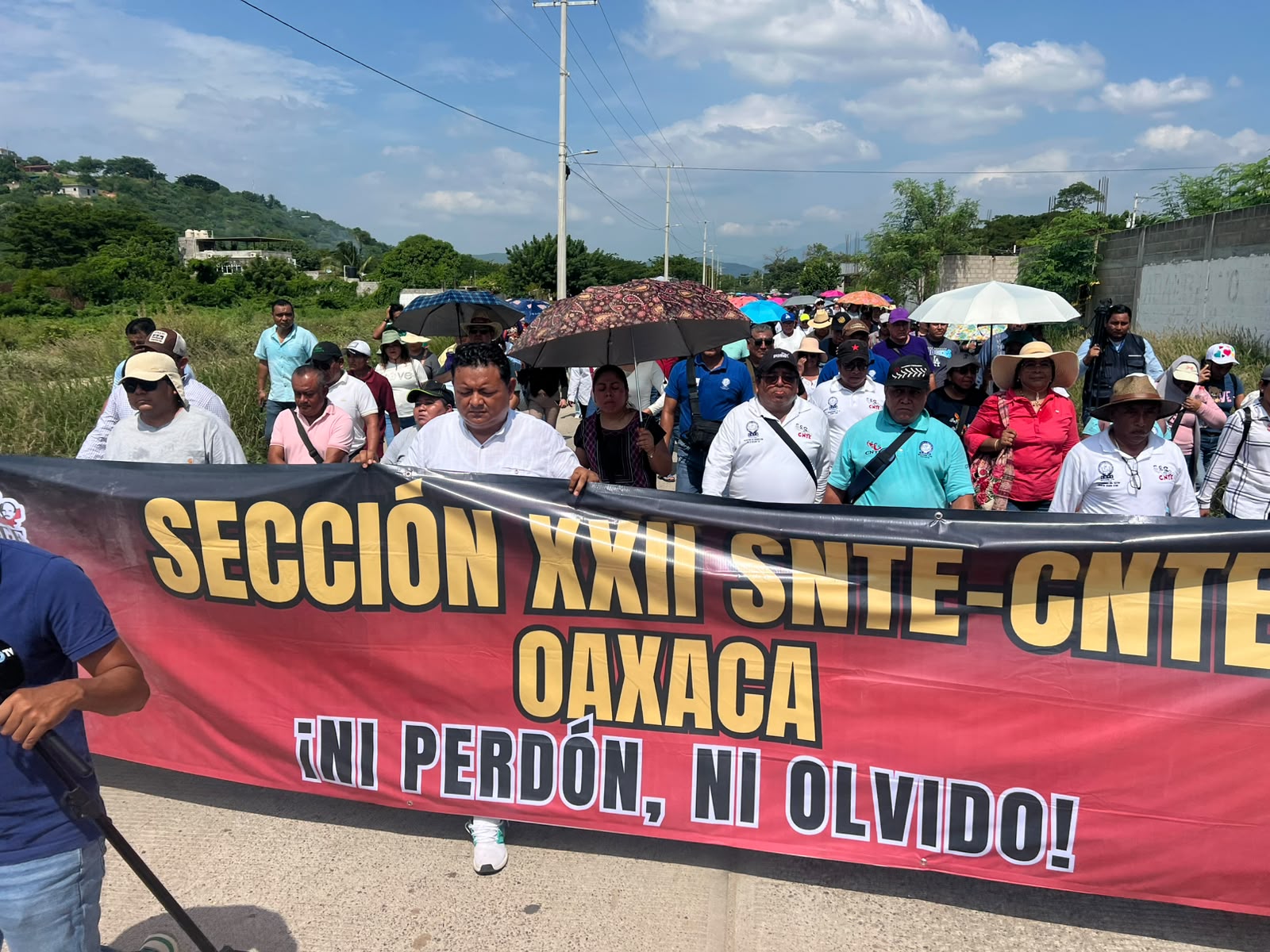 Contingente de la Sección 22 marchando con una lona que dice «¡Ni perdón, ni olvido!»