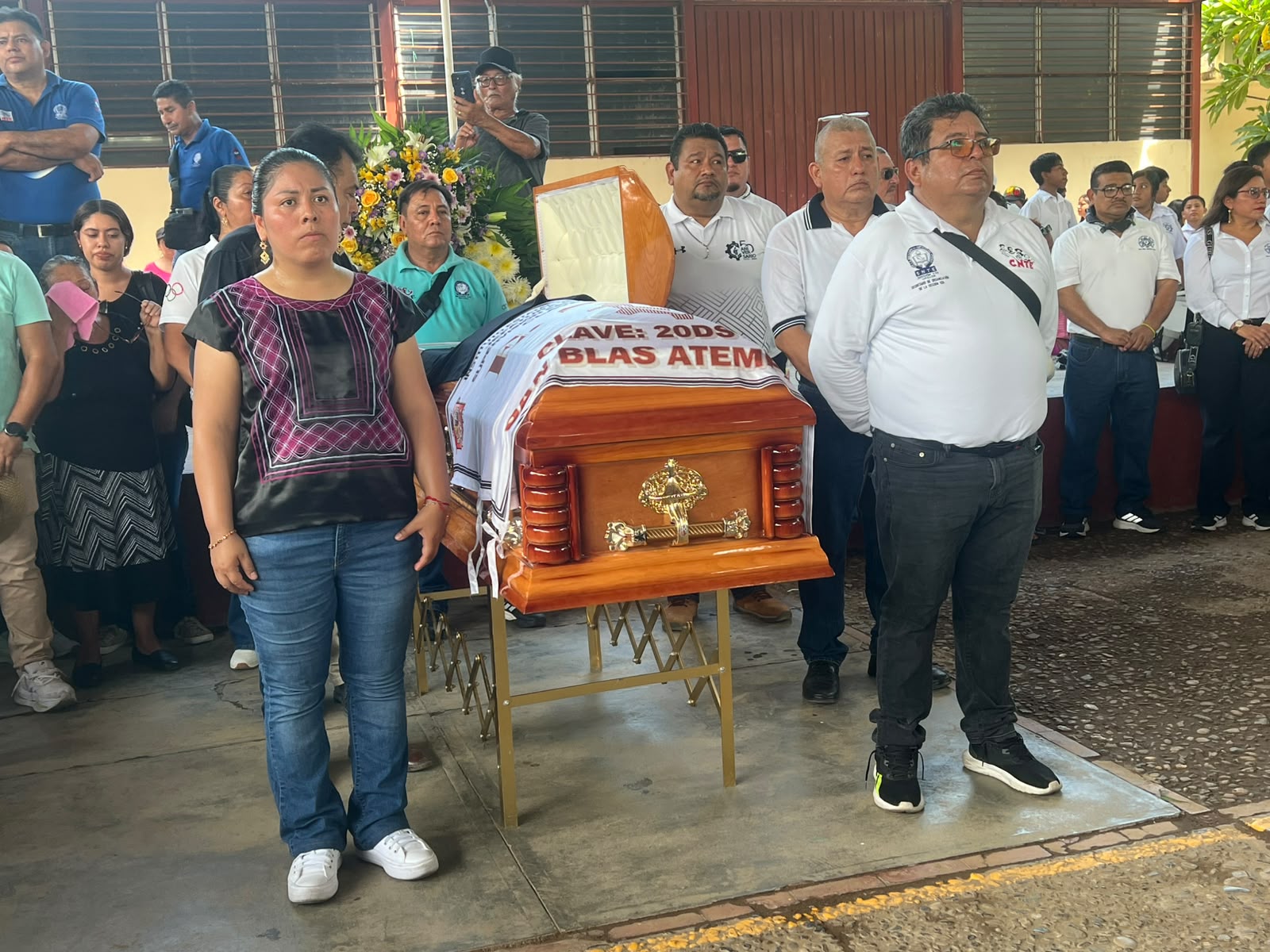 Docentes con el puño en alto junto al ataúd durante el homenaje