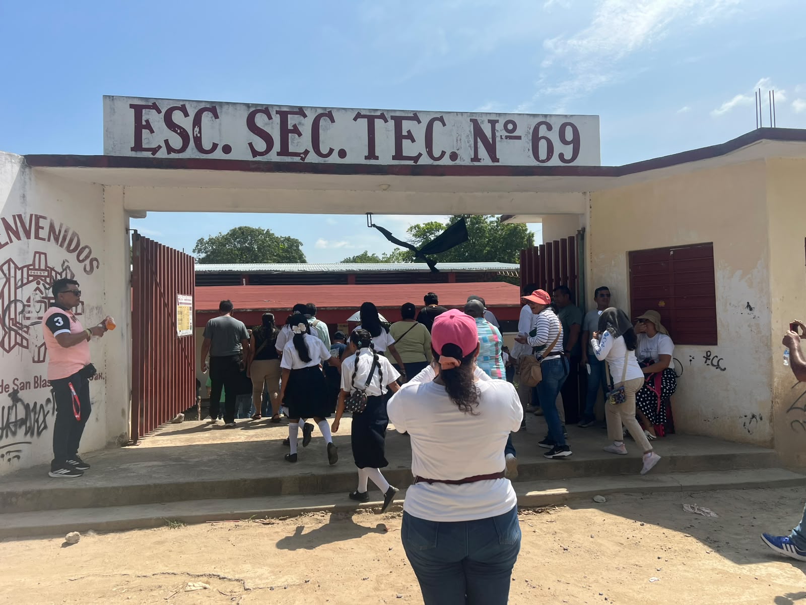 Entrada de la Escuela Secundaria Técnica 69 de San Blas Atempa, con personas ingresando