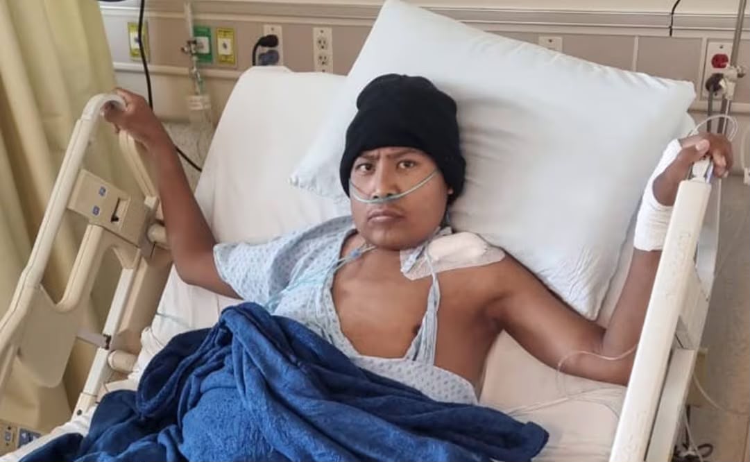 Joven con cánula nasal y vendaje en un brazo, recostado en una cama de hospital