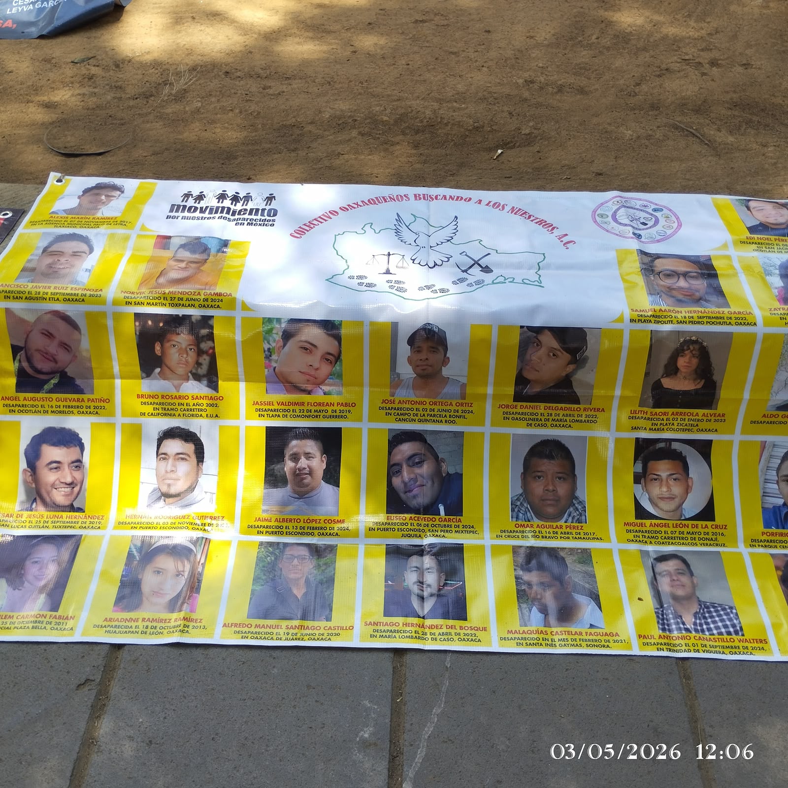 Lona amarilla del colectivo Oaxaqueños Buscando a los Nuestros con fotografías y datos de personas desaparecidas