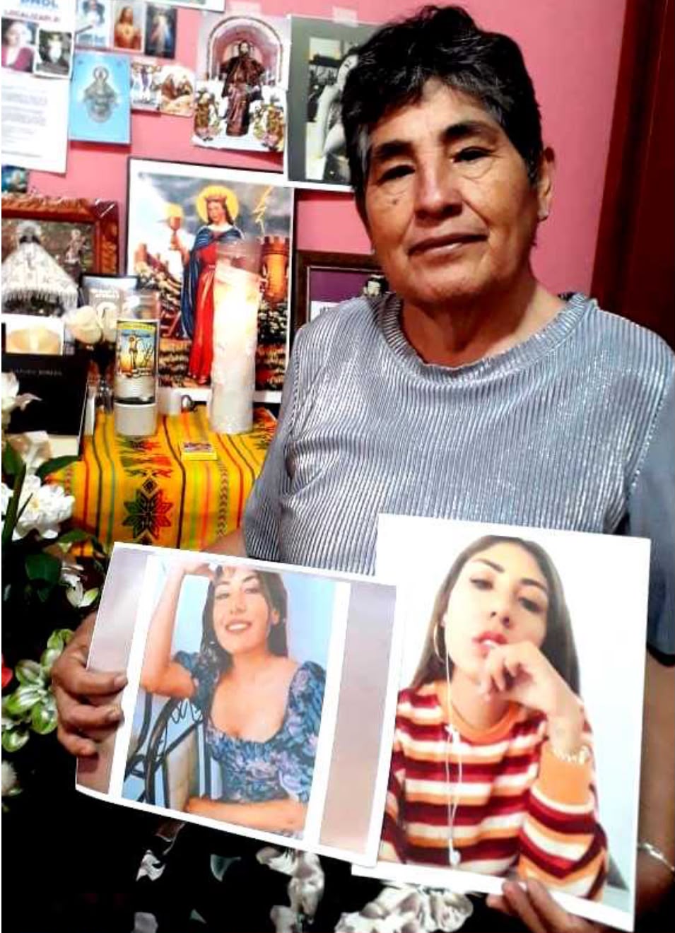 Mujer mayor sostiene dos fotografías de su hija frente a un altar doméstico