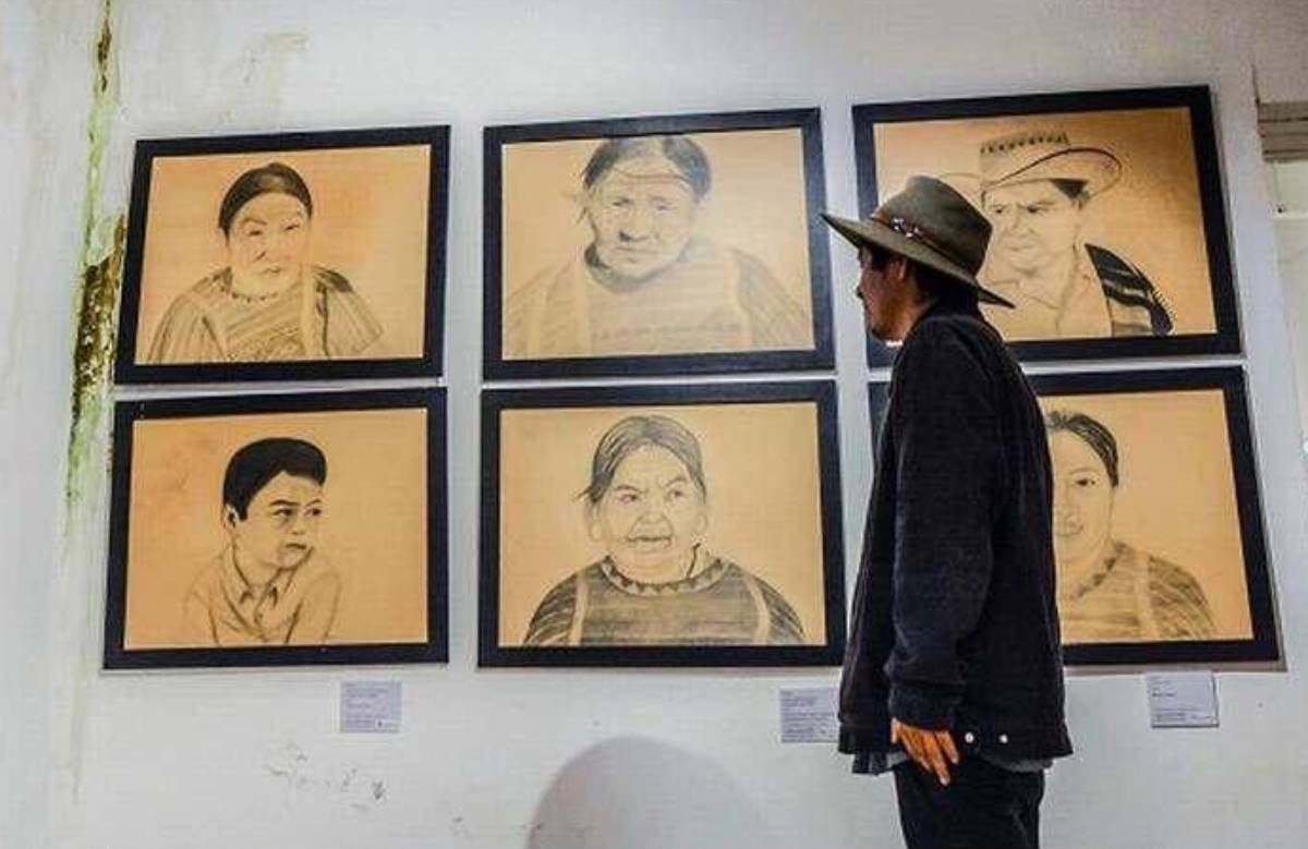 Seis retratos a lápiz enmarcados en una pared con manchas de humedad